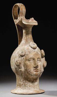 an old vase with a face on it