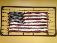 an american flag made out of cloth hanging on a wall