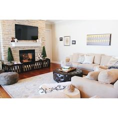 a living room filled with furniture and a flat screen tv mounted on the wall above a fireplace