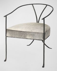 an iron chair with a white fur seat pad on the back and armrests