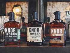 three bottles of knob creek whiskey sitting on a counter