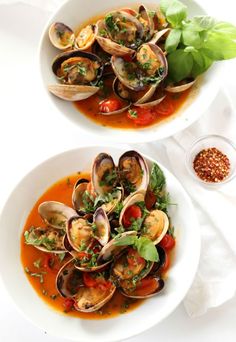 two white bowls filled with clams and sauce