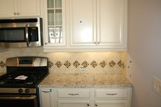 a stove top oven sitting inside of a kitchen next to a microwave above a counter