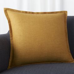 an orange pillow sitting on top of a blue couch