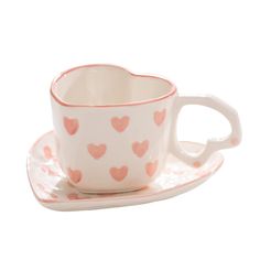 a cup and saucer with hearts on it