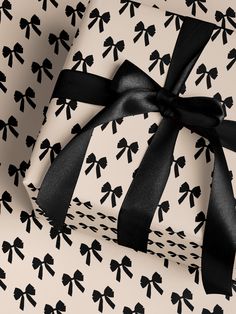 a wrapped gift box with black ribbon and bow