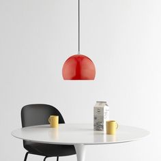 a white table with two black chairs and a red light hanging over it