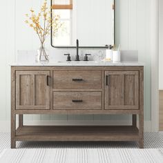 a bathroom vanity with two sinks and a large mirror above it, in front of a white painted wall