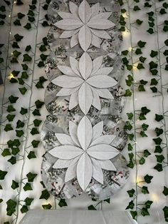 the table is decorated with white paper flowers and greenery on it's sides