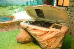 an open laptop computer sitting on top of a rock in front of a wall mural