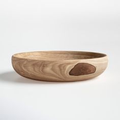 a wooden bowl sitting on top of a white table