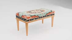 a small wooden bench with an upholstered seat and floral fabric on the top