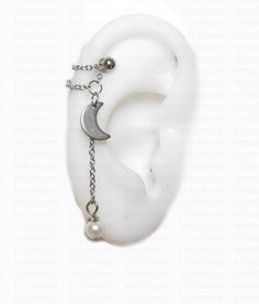 an ear with chain attached to it and a crescent charm hanging from the middle one