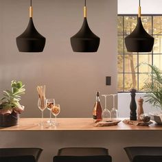 three black hanging lights above a wooden table