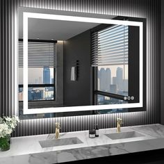 a bathroom sink with a large mirror above it and a vase full of flowers on the counter