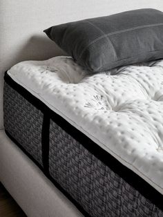 a mattress with two pillows on top of it and a pillow sitting on the bottom