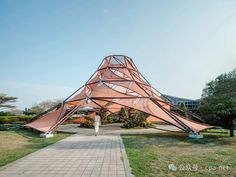 a large triangular structure sitting in the middle of a park