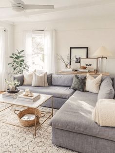 a living room filled with lots of furniture and decor on top of a white rug