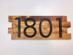 a wooden sign with the number 108 on it's front and back sides, mounted to a wall