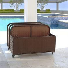 a brown wicker storage bin sitting on top of a tiled floor next to a swimming pool