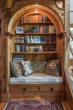 a wooden book shelf filled with lots of books next to a stair case full of books