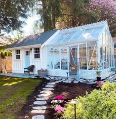 a small white house sitting in the middle of a yard