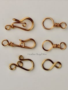 four pairs of gold plated metal wire with loop ends on white background, closeup