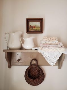 a shelf with a basket, pitcher and other items on it next to a painting