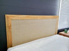 a bed with a headboard made out of wood and wicker on the side