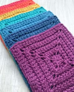 a multicolored crocheted dishcloth on a white surface