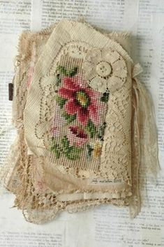 a piece of cloth with flowers on it sitting on top of an old book page