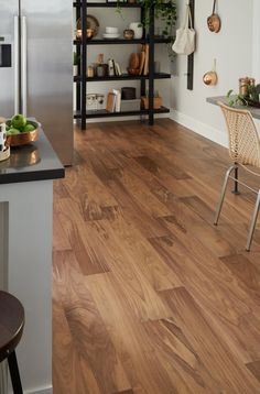 a kitchen with wood flooring and stainless steel appliances in the corner, next to a dining room table