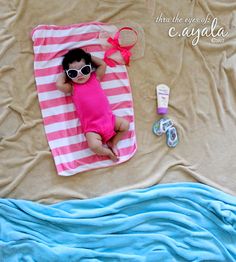 a baby laying on top of a pink and white blanket