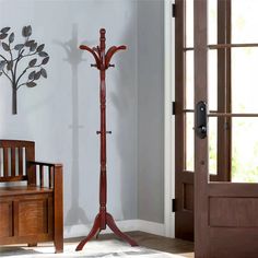 a wooden coat stand in the corner of a room with a tree on it's side