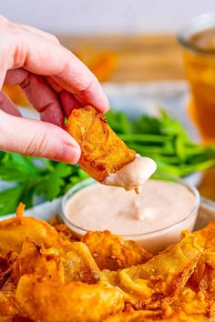 a person dipping some food into a bowl