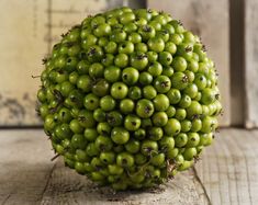 a bunch of green fruit sitting on top of a wooden table