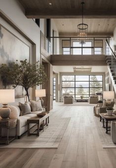 a living room filled with lots of furniture next to a stair case in front of a window