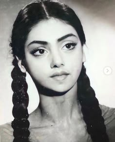 an old black and white photo of a woman with braids