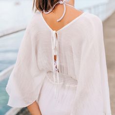 Our Smocked Waist Split Dolman Sleeve Cover-Up is a stylish beach essential that combines a decorative smocked waist with elegantly split sleeves. Versatile and comfortable, it's the ideal choice for enhancing your swimwear style. Made with lightweight and breathable fabric, this cover-up dress offers both comfort and effortless style for your sun-soaked adventures. Product code: CAA07B3M008CC Summer Vacation Top With Elastic Waistband, Summer Vacation Tops With Elastic Waistband, Summer Tops With Elastic Waistband, Summer Tops With Elastic Waistband For Vacation, Chic V-neck Smocked Top For Vacation, Casual V-neck Smocked Top For Beach, Beach Season Drawstring Dress Cover-up, Chic Smocked Top With Elastic Neckline For Vacation, White Smocked Top With Elastic Waistband For Spring