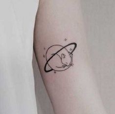 a cat with an saturn tattoo on the left inner arm and behind it is a black outline