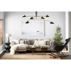 a living room filled with furniture and a christmas tree in front of a painting on the wall