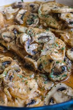 a blue bowl filled with cooked mushrooms covered in gravy