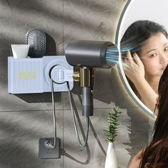 a woman is blow drying her hair in front of a mirror with an electric dryer on it