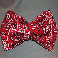 a red bow tie with black and white designs on it, sitting on a table