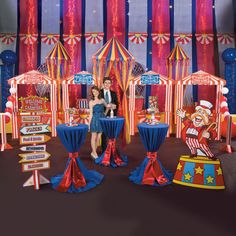 a man and woman standing next to each other in front of circus booths with clowns