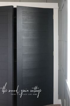 an open black door in the corner of a room with gray walls and white trim