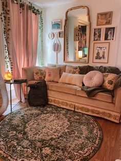 a living room filled with furniture and a large round rug on top of a hard wood floor