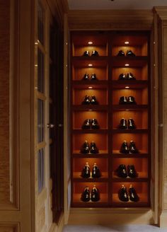 a wooden shelf filled with lots of black shoes