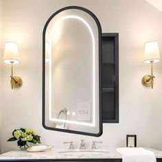 a bathroom sink with a lighted mirror above it