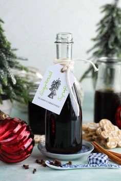 homemade gingerbread syrup in a glass bottle on a plate with christmas decorations around it